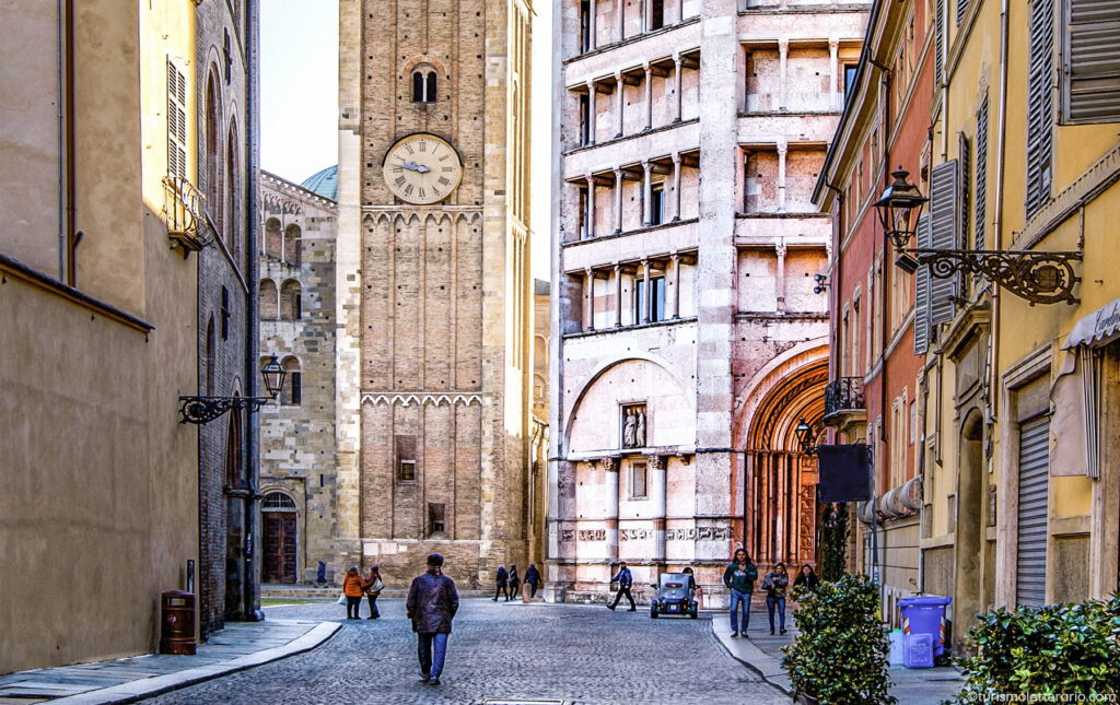 Scorcio di una strada del centro di Parma con il battistero sullo sfondo